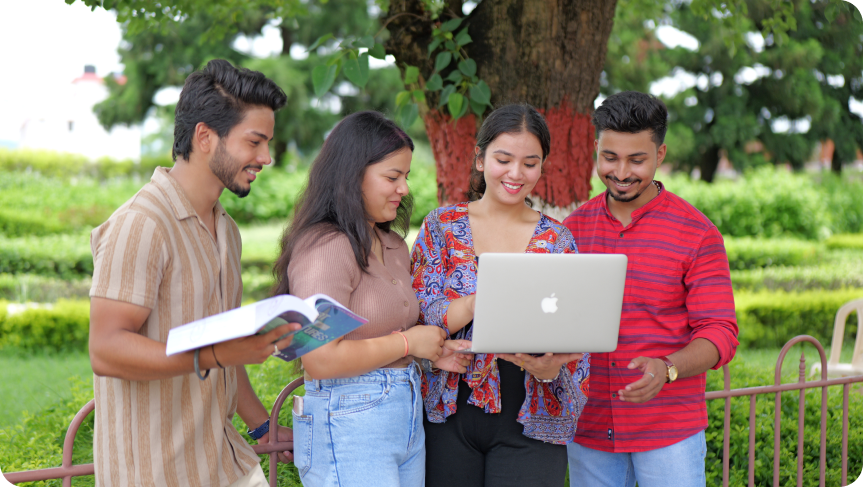 Group of students studying together and looking at a laptop