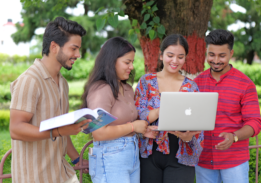 Students on campus looking at a laptop