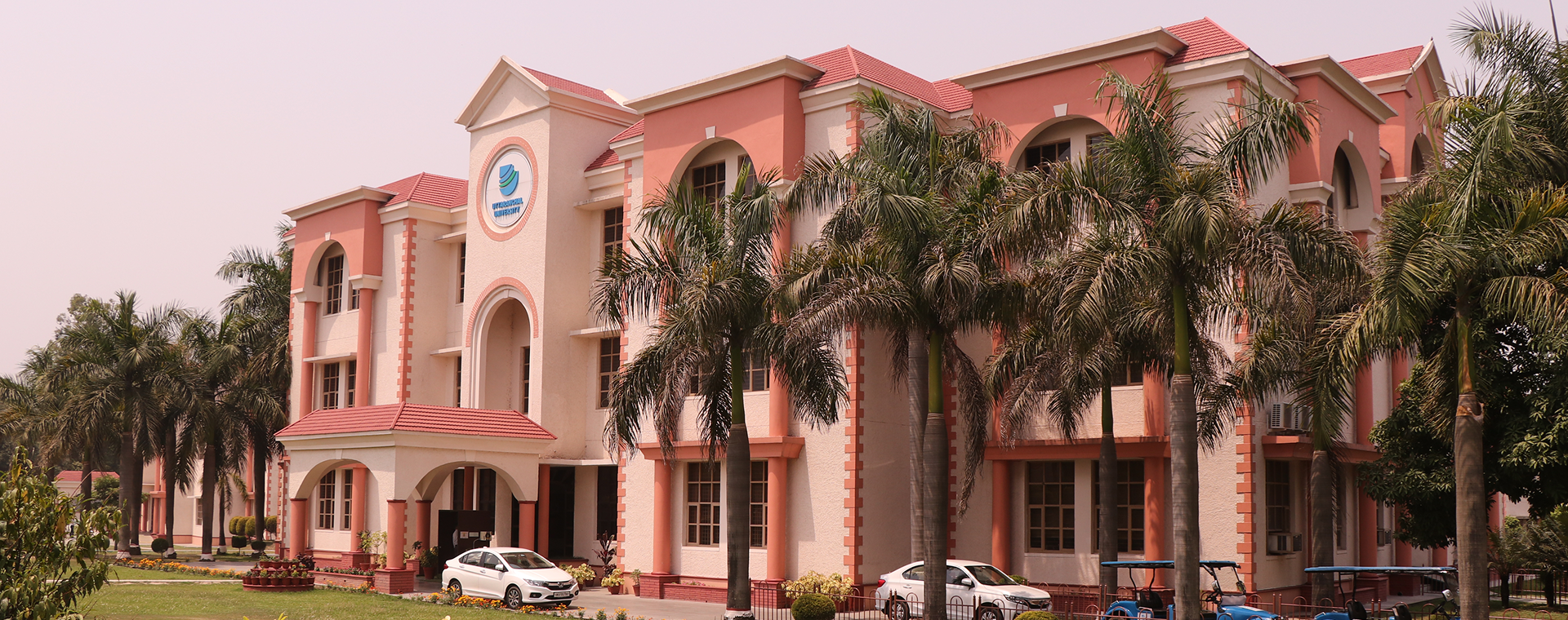 Uttaranchal University Main Building with Palm Trees